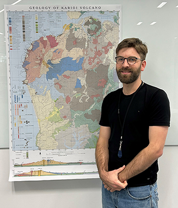 Image -  Oliver McLeod stands alongside his volcanic map of Karioi