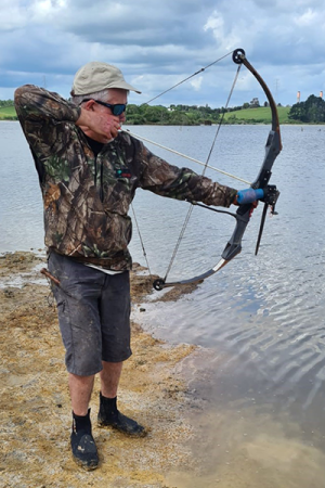 Peter Harrison takes aim at koi carp in the water 