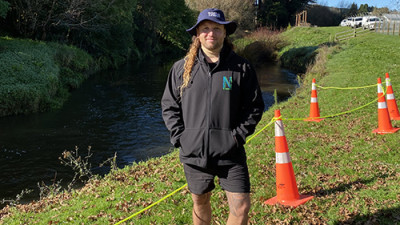 Image of a man standing in a field with a bucket hat on