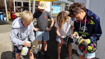 Image of a group of kids scrubbing shoes