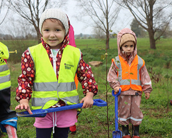 Little Kiwis Corner early childhood centre all dressed in wet weather gear ready to plant trees